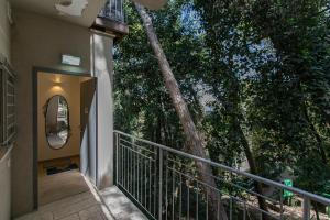 einen Balkon mit einem Baum neben einem Gebäude in der Unterkunft Carmel Boutique Apartments - Urban Forest in Haifa