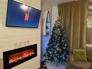a living room with a christmas tree and a television at Appartement Vert du Palais - Relaxation Centrale in Le Palais