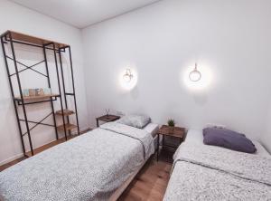 2 camas en una habitación con paredes blancas en K-Town - Apartments ViaBaltic Kaunas en Kaunas