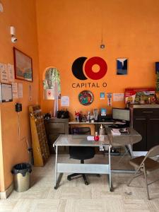 Hotel Villas Ajijic, Ajijic Chapala Jalisco في آجيجيك: مكتب بحائط برتقالي وطاولة مع جهاز كمبيوتر