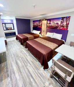 Cette chambre d'hôtel comprend 2 lits et des murs violets. dans l'établissement Paradise Inn, à Montebello