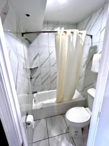 La salle de bains est pourvue de toilettes, d'une baignoire et d'un lavabo. dans l'établissement Paradise Inn, à Montebello