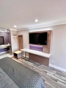 ein Hotelzimmer mit einem großen Flachbild-TV in der Unterkunft Paradise Inn in Montebello
