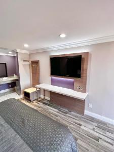 a hotel room with a large flat screen tv at Paradise Inn-Montebello,Los Angeles in Montebello +6 photos
