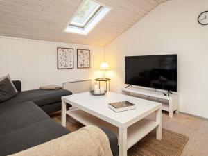 sala de estar con sofá, mesa y TV en Holiday home Ålbæk XXVIII, en Ålbæk