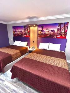 une chambre d'hôtel avec 2 lits et un tableau mural dans l'établissement Paradise Inn, à Montebello