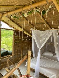 a bed in a wooden hut with a roof at biohotel tatacoa Qji in Villavieja