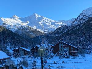 a snow covered mountain with houses and a street light at Chalet Olympie, Appartement avec balcon et vue montagne, ski aux pieds, Méribel-Mottaret in Méribel