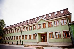 ein großes grünes Gebäude mit braunem Dach in der Unterkunft Hárs Thermál Hotel in Gyomaendrőd