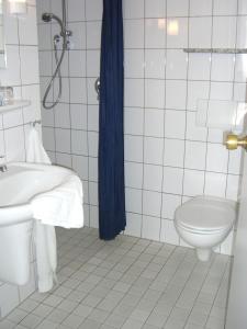 ein weißes Bad mit einem Waschbecken und einem WC in der Unterkunft Zur Alten Post in Nottuln