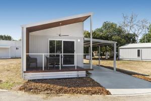 a small house with a covered porch in a field at Ingenia Holidays Townsville in Townsville