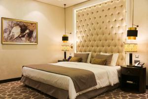a bedroom with a large bed with a large headboard at The B Premiere Hotel in Doha