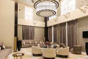 a lobby with couches and tables and a chandelier at The B Premiere Hotel in Doha