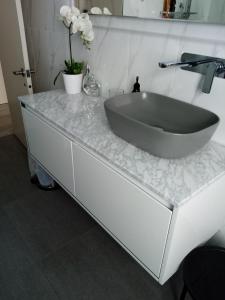 a bathroom with a large sink on a counter at Two rooms with one queen size bed in each room one bathroom for the two rooms in Mount Maunganui