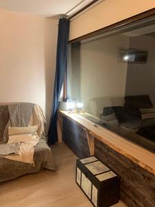 a room with a mirror and a couch and a chair at Le cocon des écureuils in Font-Romeu-Odeillo-Via
