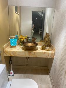 a bathroom counter with a sink and a mirror at Super Casa Piscina Com Cascata in Manaus