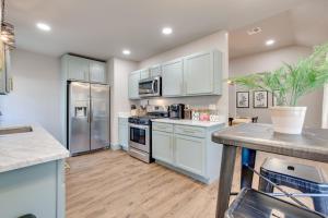 una cocina con armarios blancos y electrodomésticos de acero inoxidable en Charming 2 bed 1 bath Tudor - Near Plaza & Midtown en Oklahoma City