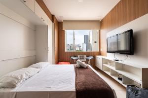 1 dormitorio con 1 cama grande y TV de pantalla plana en AÃ - Studio Aconchegante em Higienópolis: Próximo ao Mackenzie e Metrô!, en São Paulo