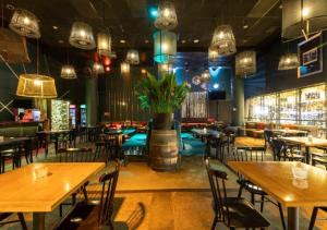 a restaurant with wooden tables and chairs and lights at Hotel Casino Talca in Talca