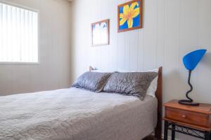 um quarto com uma cama e um candeeiro azul sobre uma mesa em Silversands Beach House em Berrara
