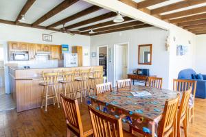 uma sala de jantar e cozinha com mesa e cadeiras em Silversands Beach House em Berrara