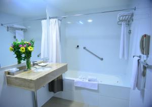 a bathroom with a sink and a vase of flowers at Hotel Casino Talca in Talca