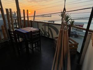 a balcony with a table and chairs and the ocean at Totora Surf Hostel in Huanchaco