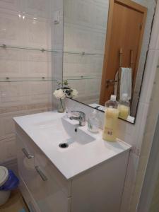 ein Badezimmer mit einem weißen Waschbecken und einem Spiegel in der Unterkunft Vivenda Rosa Lagos in Lagos
