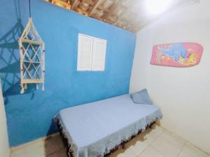 a room with a blue wall with a bed in it at Casa Mar in Baía Formosa
