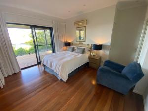 a bedroom with a bed and a blue chair at Balmoral 575 in Montville