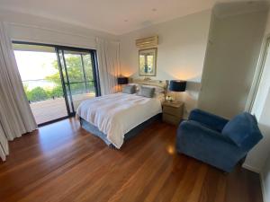 a bedroom with a bed and a blue chair at Balmoral 575 in Montville +34 photos