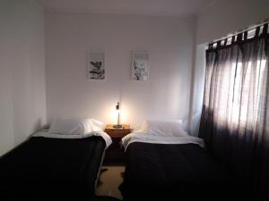2 camas en una habitación con una lámpara en una mesa en Marina 4 en Mar del Plata