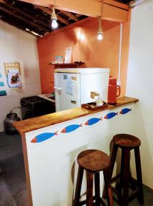 una cocina con barra y 2 taburetes en Casa Mar, en Baía Formosa