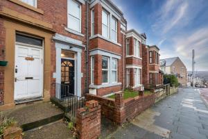 a brick house with a white door on a street at City Centre Large Luxury Rooms Free Parking in Gateshead