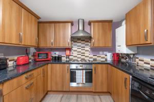 uma cozinha com armários de madeira e um forno com placa de fogão em City Centre Large Luxury Rooms Free Parking em Gateshead