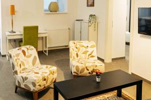 a living room with two chairs and a table at Vila Jakopič apartments in Ljubljana