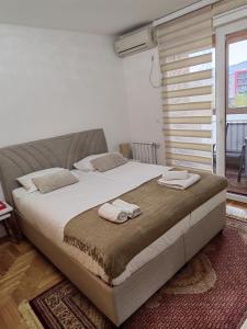 ein Schlafzimmer mit einem großen Bett mit Handtüchern darauf in der Unterkunft LoRed apartment in Sarajevo