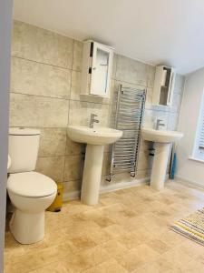 a bathroom with a toilet and two sinks at Chatham hilltop view in Chatham