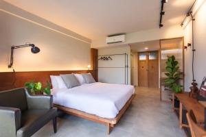 1 dormitorio con 1 cama blanca grande y 1 silla en GalileOasis Boutique Hotel en Bangkok