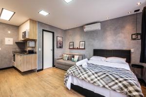 1 dormitorio con 1 cama y 1 sofá en Sky155 - Studio c/ Vaga Próx. à Estação da Luz: Seu Refúgio Urbano!, en São Paulo