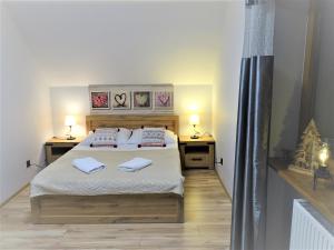 sypialnia z łóżkiem z dwoma stołami i dwoma ręcznikami w obiekcie Góralska Osada Karpacz -Wood House 8 osobowy Dom Lux w mieście Karpacz