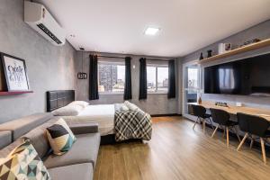 Habitación de hotel con cama y sofá en Sky155 - Studio c/ Vaga Próx. à Estação da Luz: Seu Refúgio Urbano!, en São Paulo