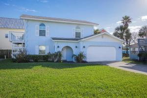 a white house with a garage in a yard at Seaside Bungalow in Saint Augustine