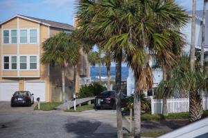 a house with palm trees in front of the ocean at Seaside Bungalow in Saint Augustine