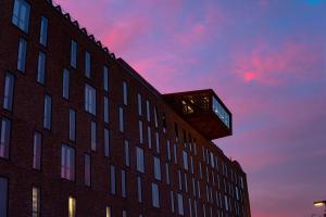 a building with a tower on top of it at sunset at The Winery Hotel, WorldHotels Crafted in Solna