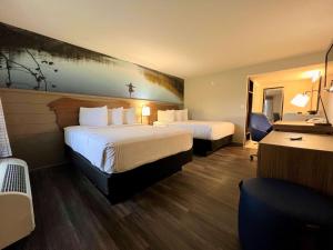 a hotel room with two beds and a desk at The Inn At Tree City, BW Signature Collection in McMinnville