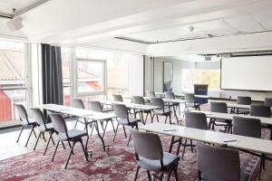 a classroom with tables and chairs and a whiteboard at Radisson Blu Royal Garden Hotel, Trondheim in Trondheim