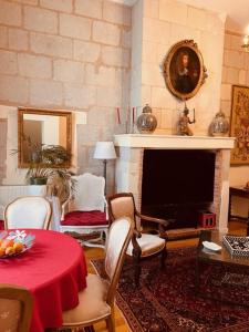 ein Wohnzimmer mit einem Tisch und einem Kamin in der Unterkunft CLUB NAPOLEON SAUMUR in Saumur
