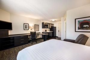 a hotel room with a bed and a desk at Sonesta Simply Suites Dallas Galleria in Dallas