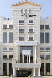 a large white building with a clock on it at The B Premiere Hotel in Doha